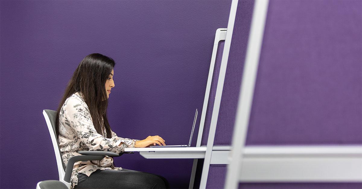 成年女性坐在办公桌前用电脑工作